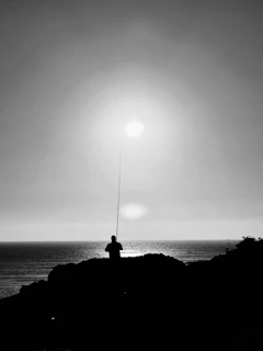 An influencer showcasing premium fishing rods on a serene Florida pier at sunrise, casting a silhouette.