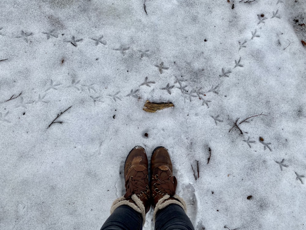 a pair of feet in shoes on a snowy ground