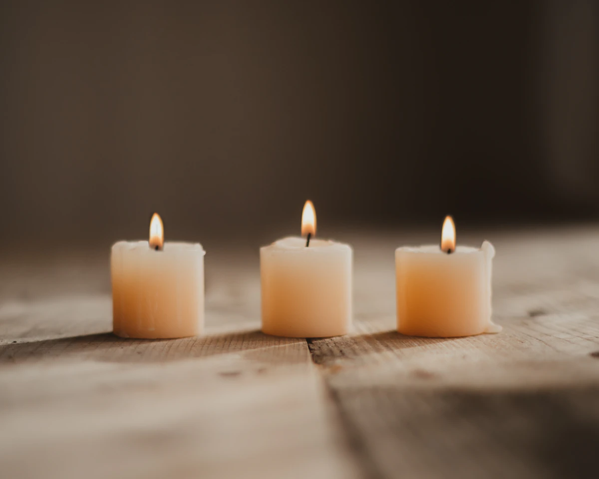 Trois bougies allumées sur une table en bois