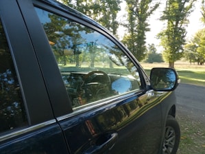 A sparkling clean windshield reflecting sunlight on a parked car.