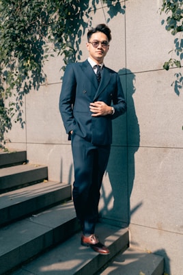 a man in a suit standing on a staircase
