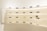 A variety of sunglasses are displayed on curved, backlit shelves in a modern showroom. The shelves are mounted on a light-colored wall, creating a clean and minimalist aesthetic. Different styles and colors of sunglasses are neatly arranged, with some featuring labels or small display signs.