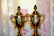 Close-up of elegant gold trophies arranged on a dark navy blue tablecloth under soft stadium lighting.