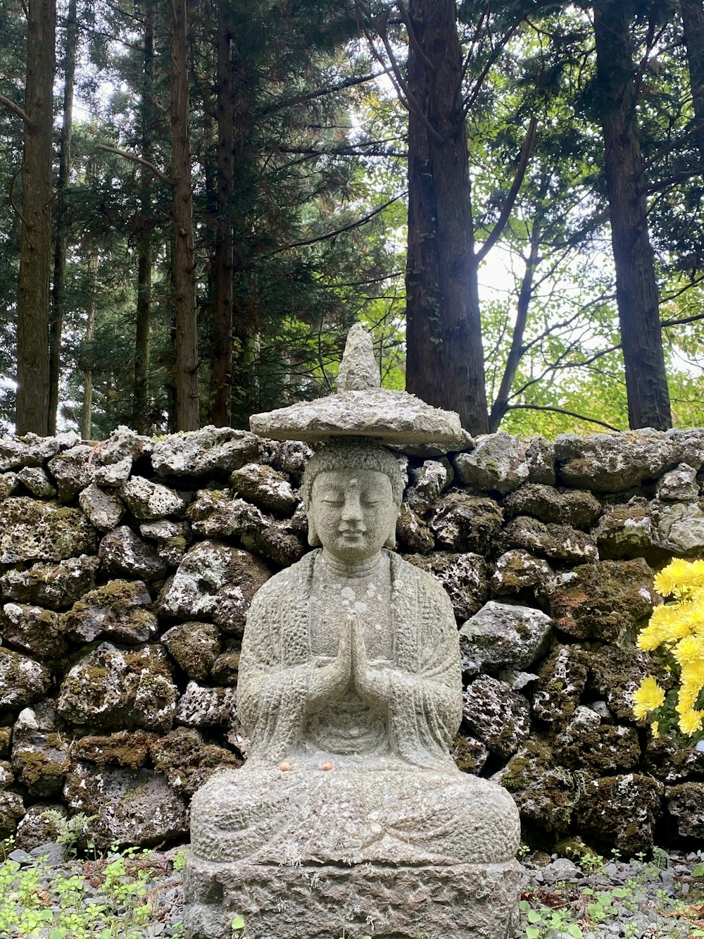 a stone statue in a forest