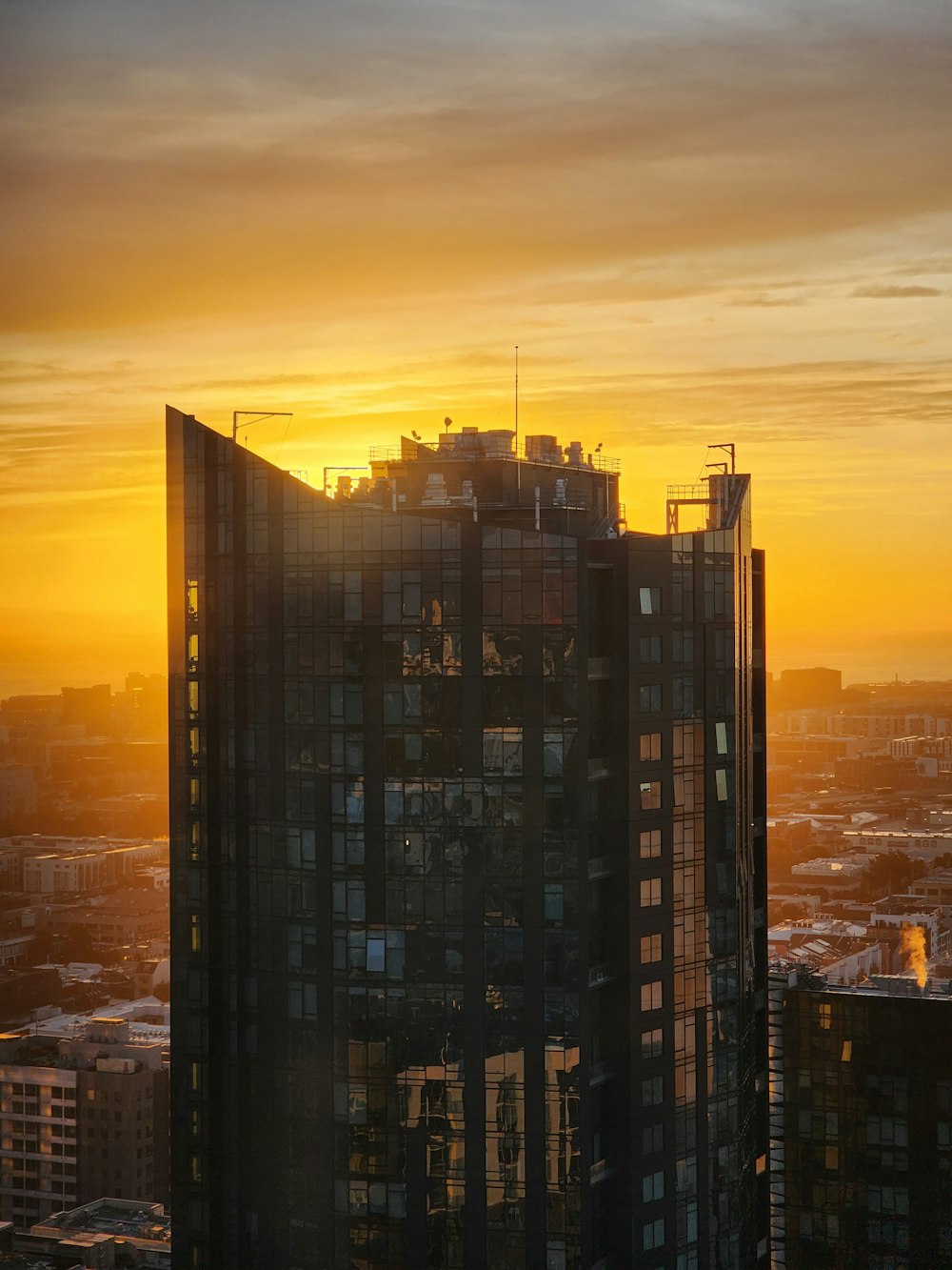 a tall building with a sunset in the background