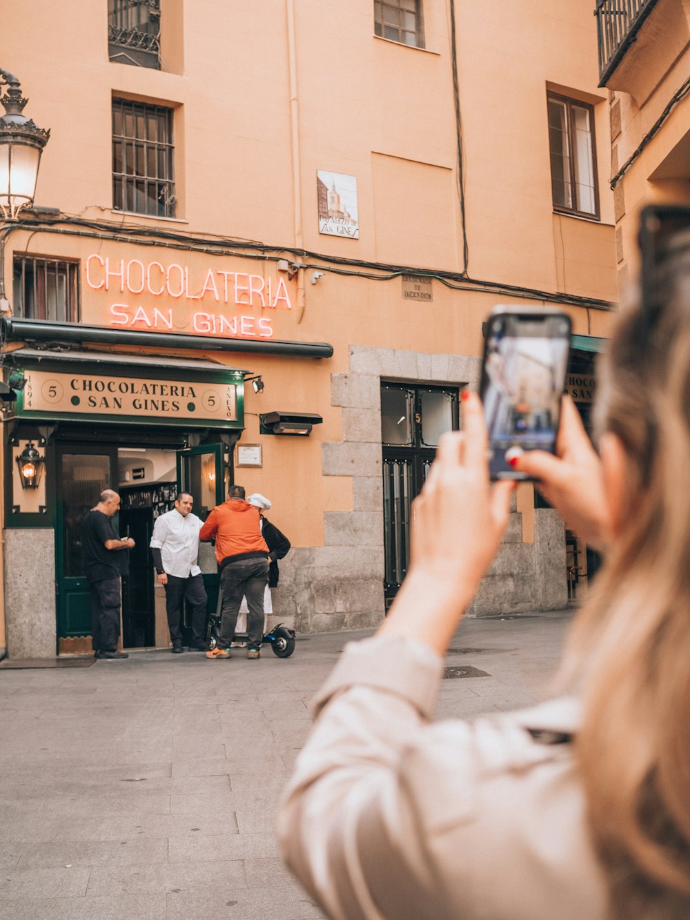 a person taking a picture of a group of people on a street