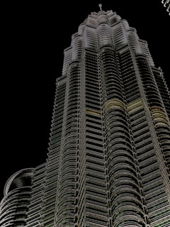 A sleek, futuristic high-rise tower illuminated at dusk, showcasing imarat's precision engineering and architectural innovation.