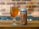 A glass filled with a golden, bubbly beverage is placed on a wooden surface next to a can with an artistic design labeled 'KAIHE DDH CHINOOK IPA'. The background features a blurred brick wall.