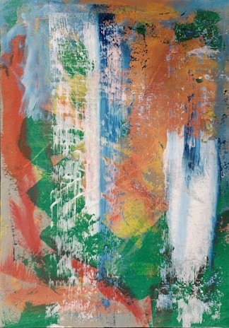 An abstract painting with a mix of vibrant colors applied in layers and streaks. Blue, green, orange, red, and white are prominent, blending together with a textured appearance. The layered brushstrokes and splatters create a dynamic and chaotic composition, suggesting movement and energy.