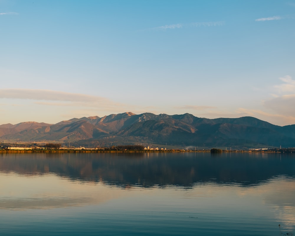 a body of water with mountains in the background