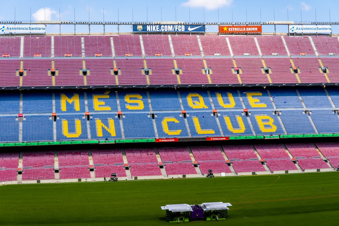 a sports stadium with a field and a field with Camp Nou in the background,