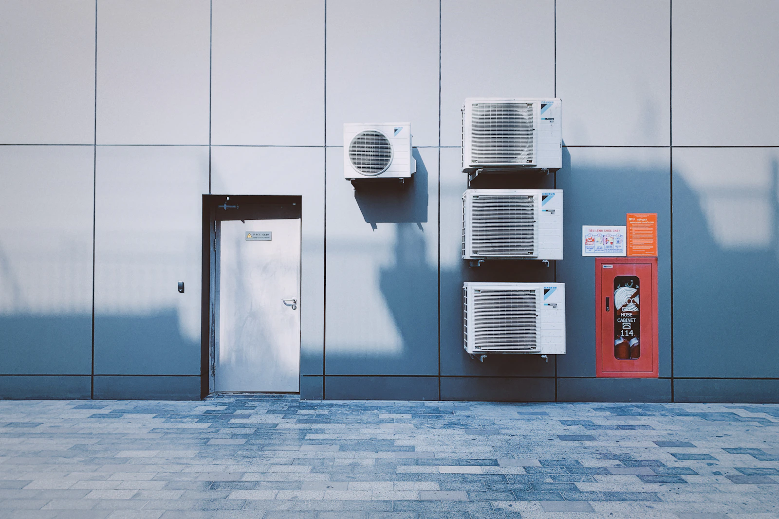 Split-system AC units mounted on an exterior wall, exposed to the weather year-round
