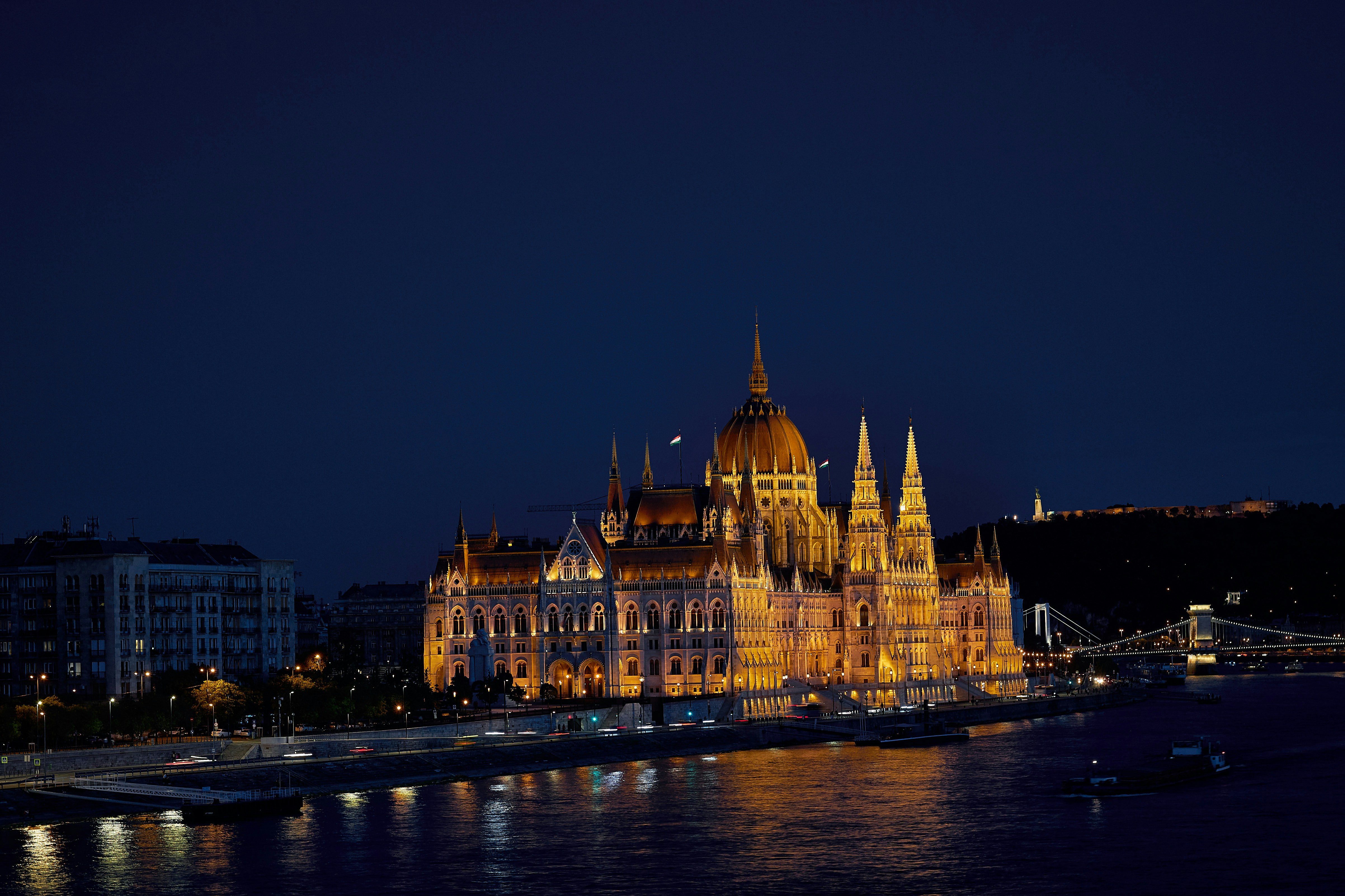 a large building with a gold roof by a body of water