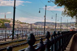 A panoramic view of a tramway system running through a European cityscape at dusk.