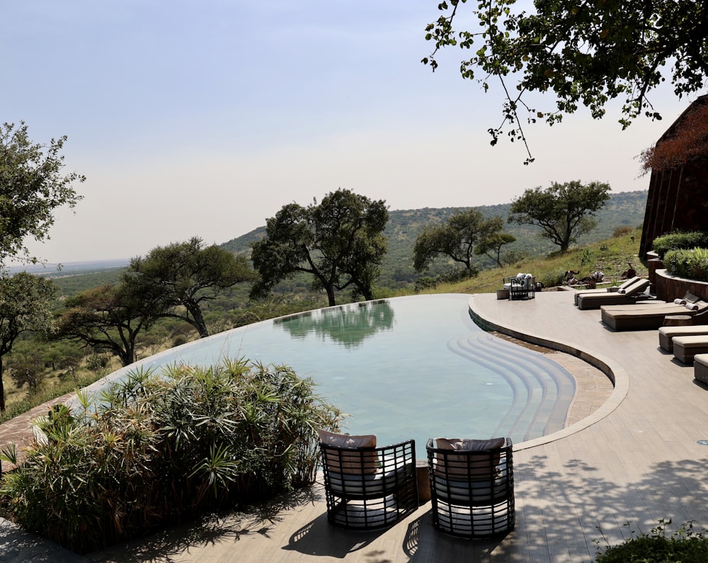 a pool with a patio and chairs