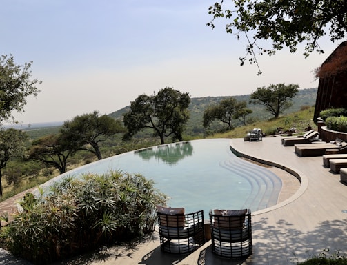 a pool with a patio and chairs