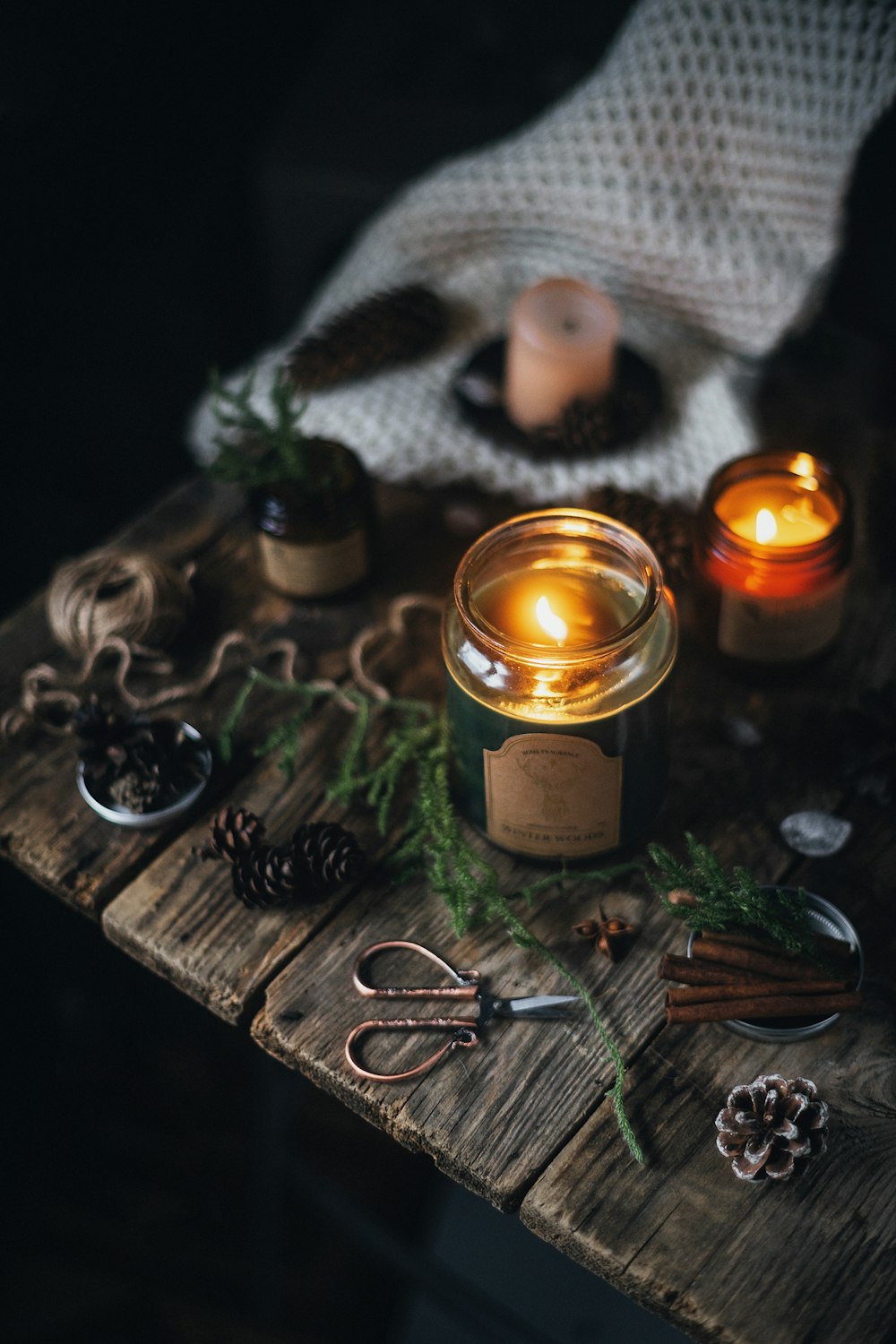 a group of candles and a pair of scissors on a table