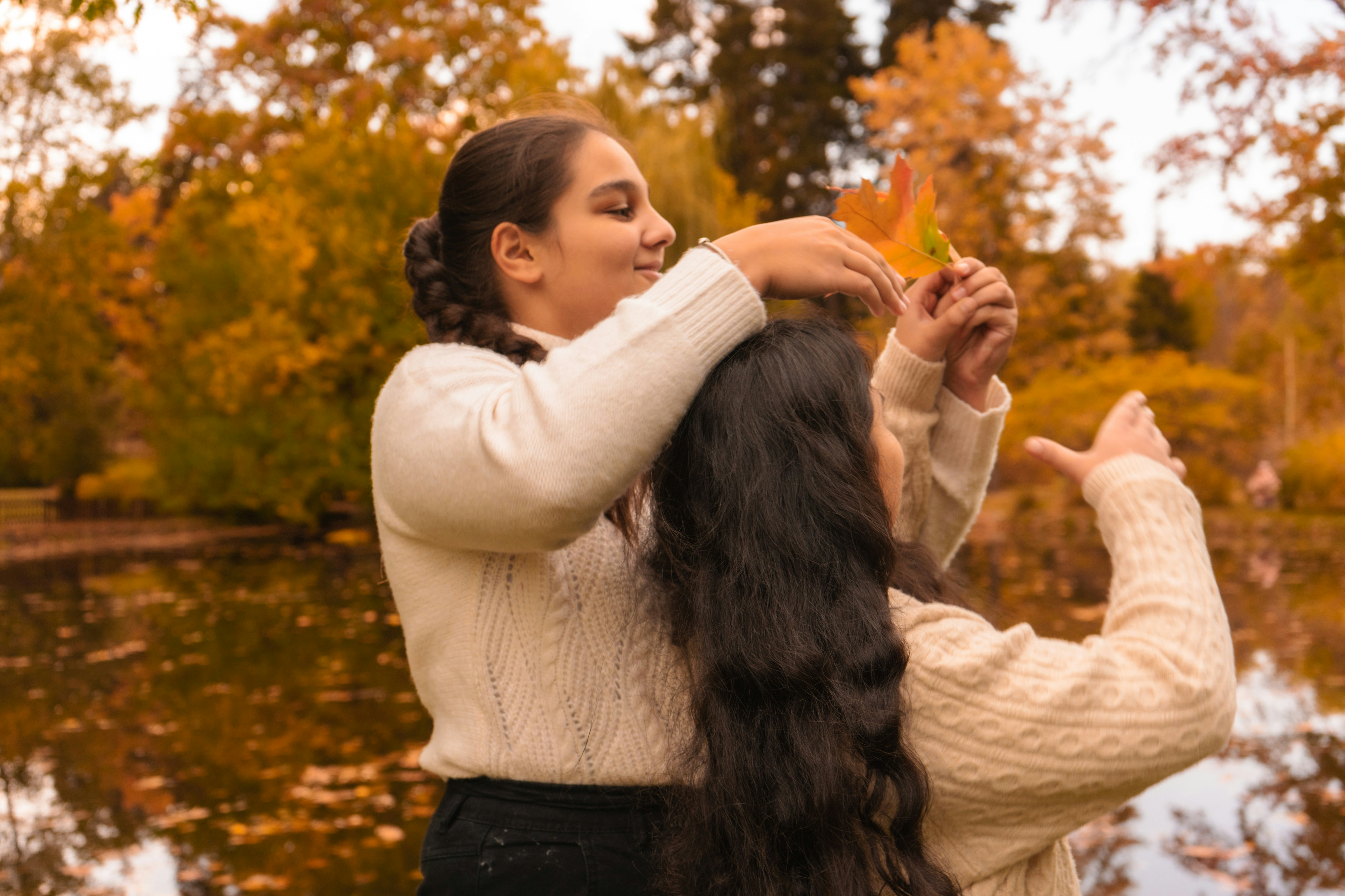 a person holding a carrot and another woman holding the hands up
