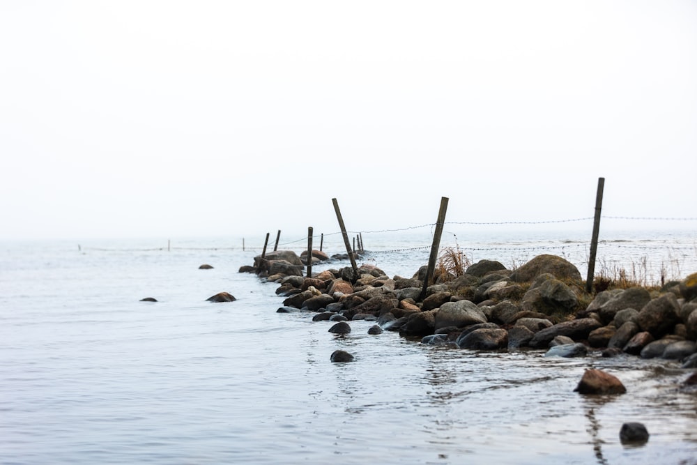 a rocky beach with a fence