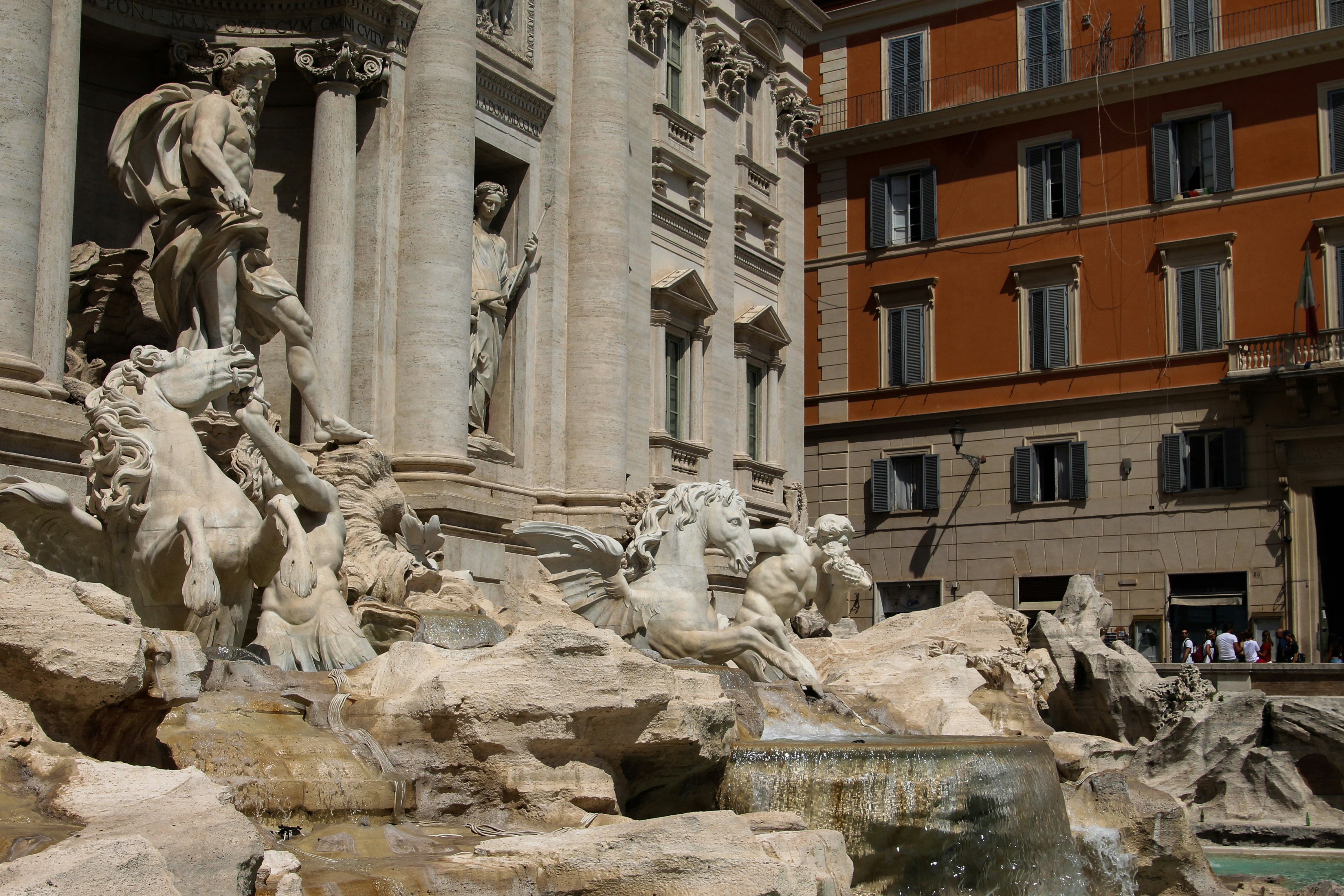 a fountain with statues in front of a building