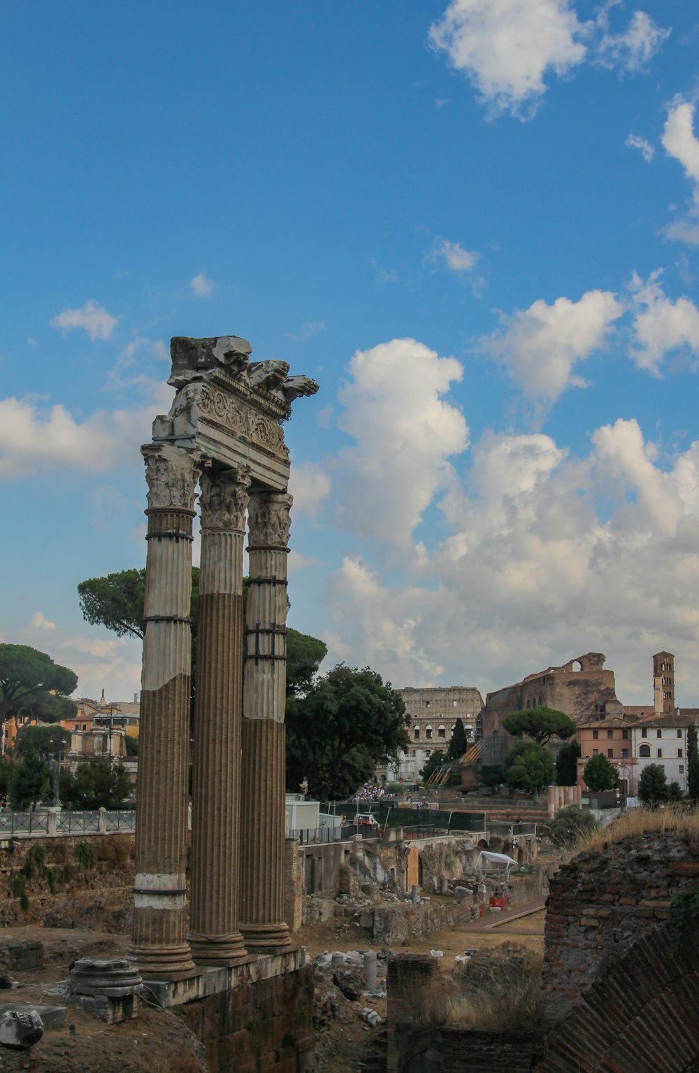 a stone structure with columns and a city in the background