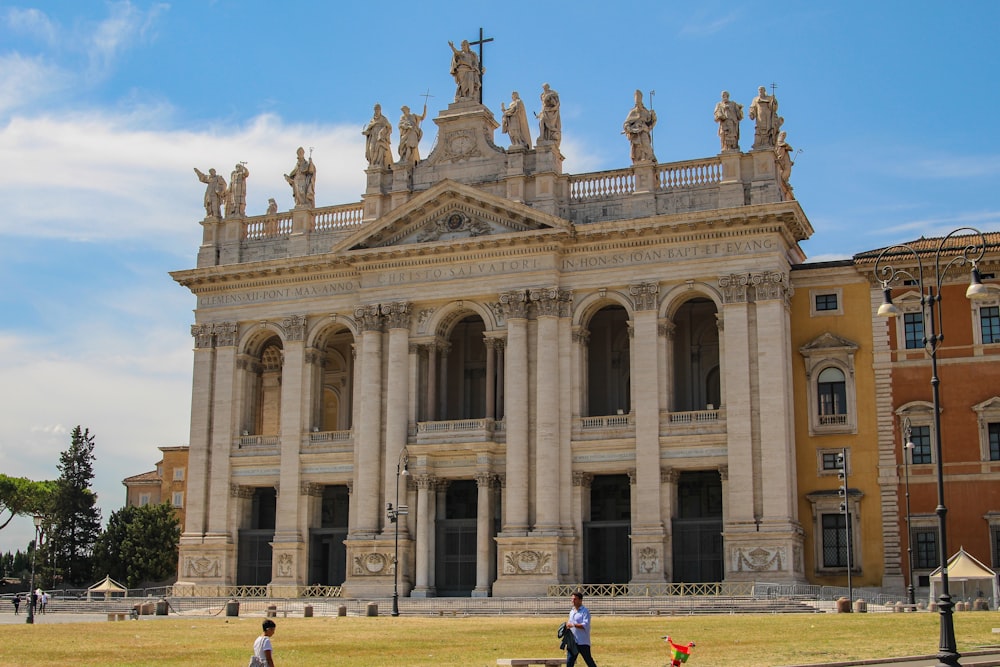 a large building with statues on the top with Archbasilica of St. John Lateran in the background