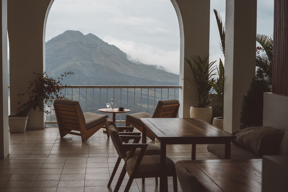 eine Terrasse mit Stühlen und Tischen und einem Gewässer im Hintergrund