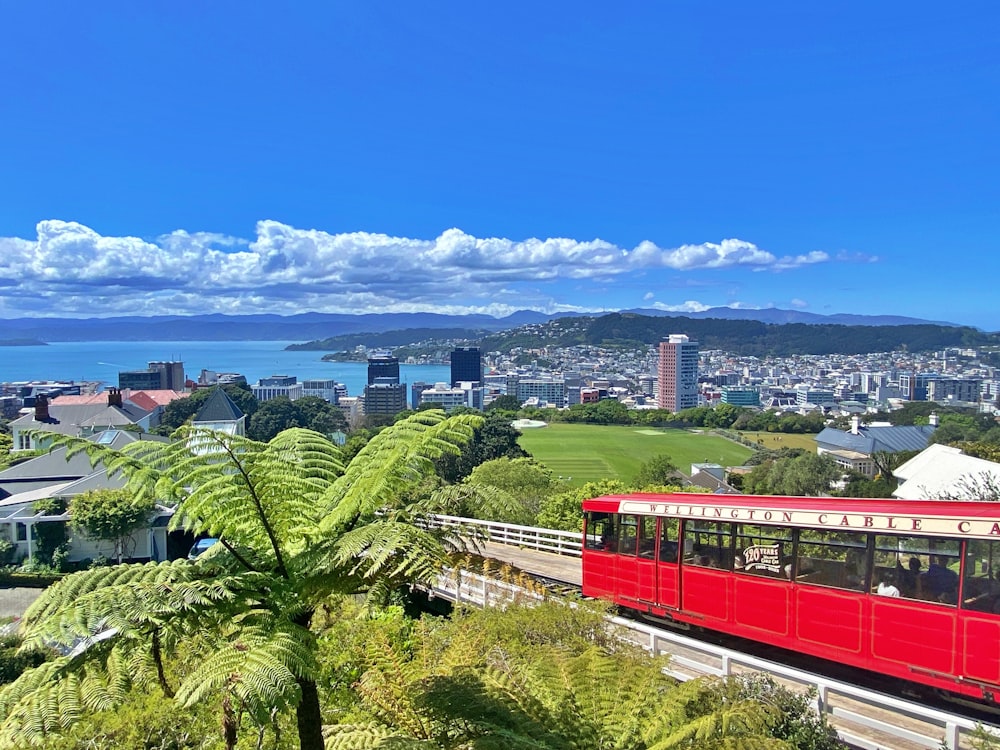 a red train on a track with Wellington Cable Car in the background