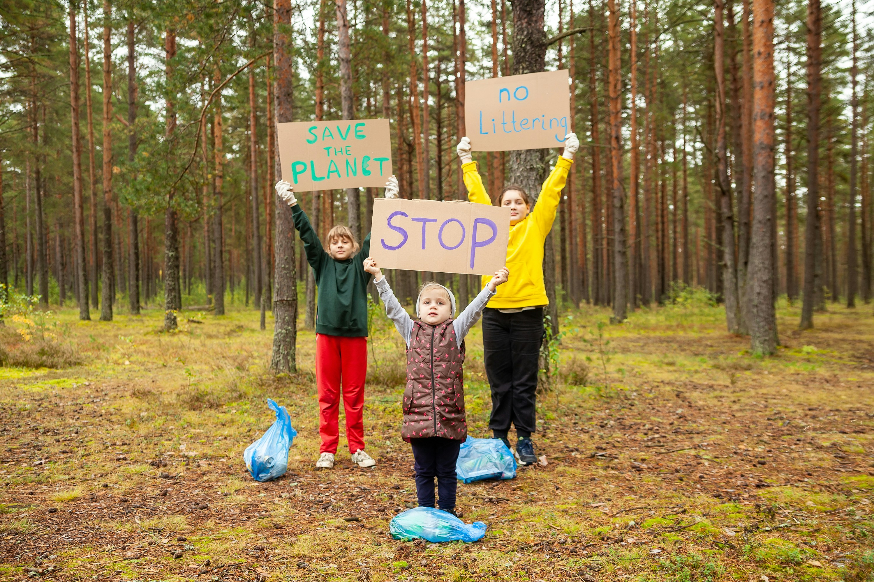 a group of people holding signs in the woods
