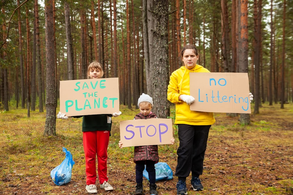 a group of people holding signs in the woods