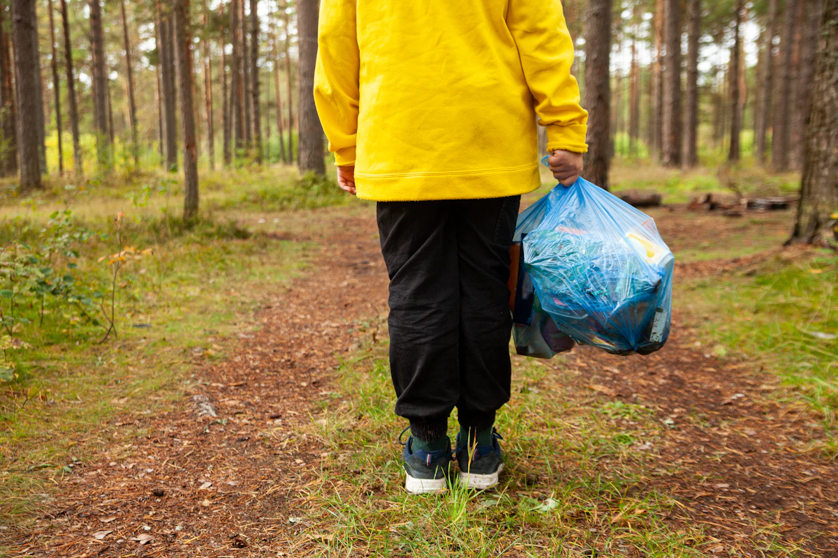 Person carrying a bag of yard and household trash