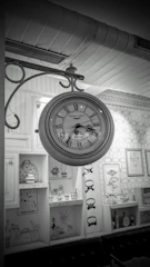 A cozy living room wall featuring a sleek digital clock and a classic round wall clock side by side.