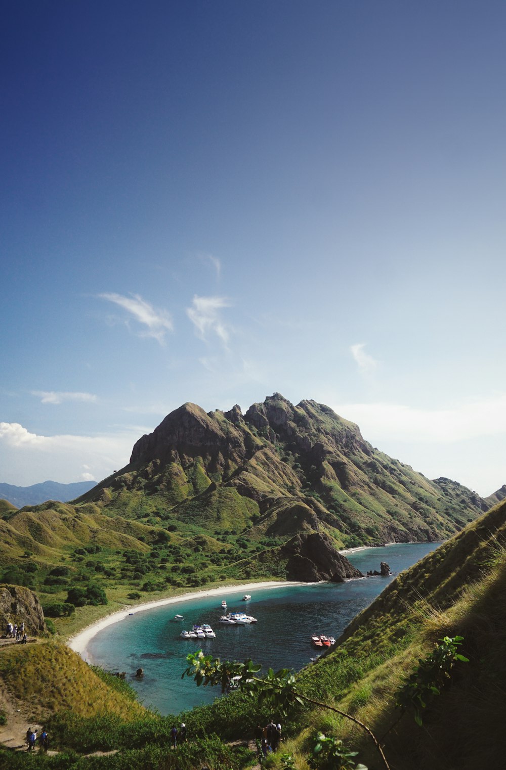 a body of water with boats in it by a mountain