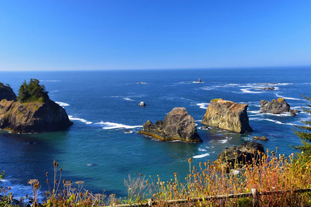 A vibrant coastal scene from the Aeolian Islands with workshop members exploring volcanic rock formations.