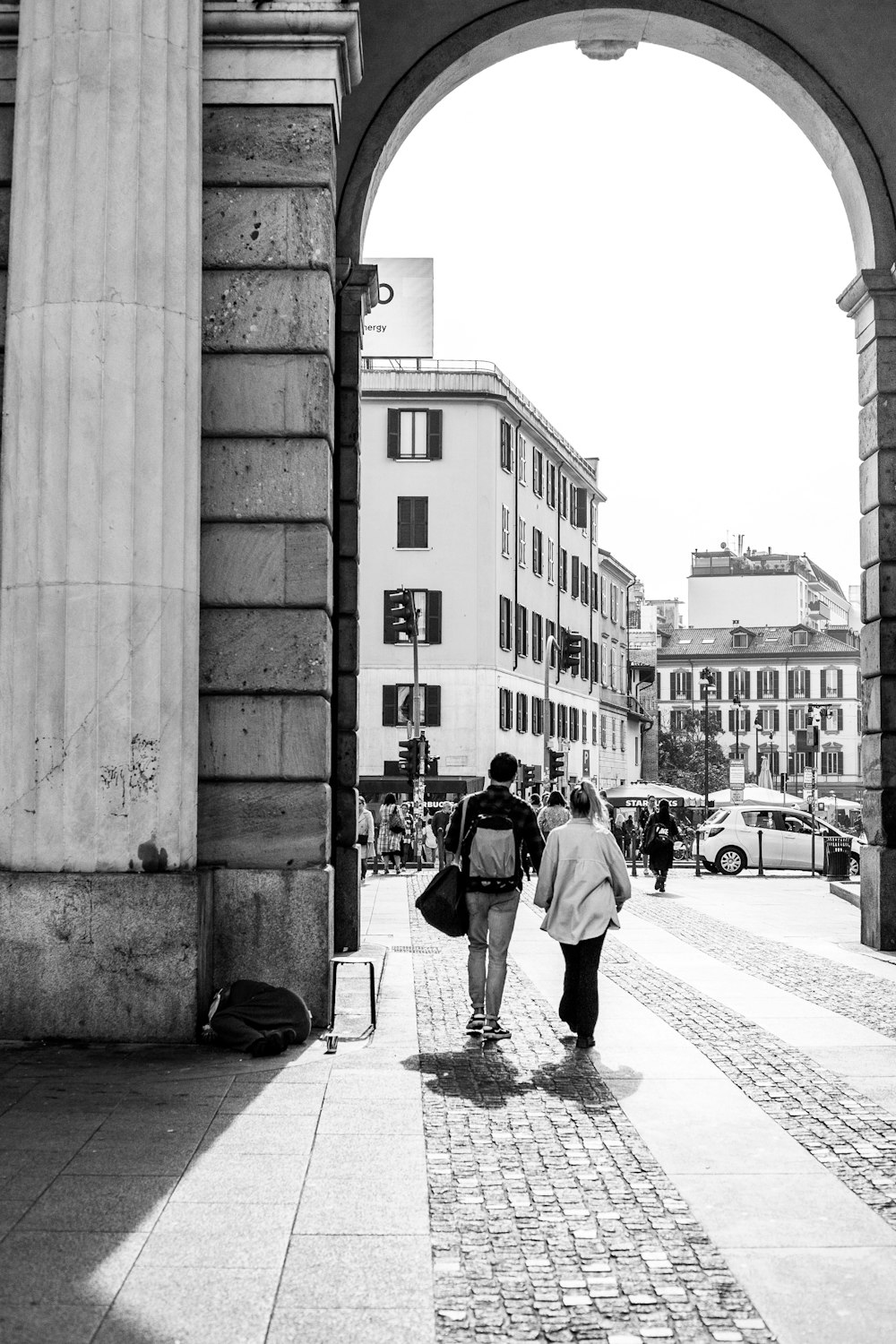 a couple of people walking under a bridge