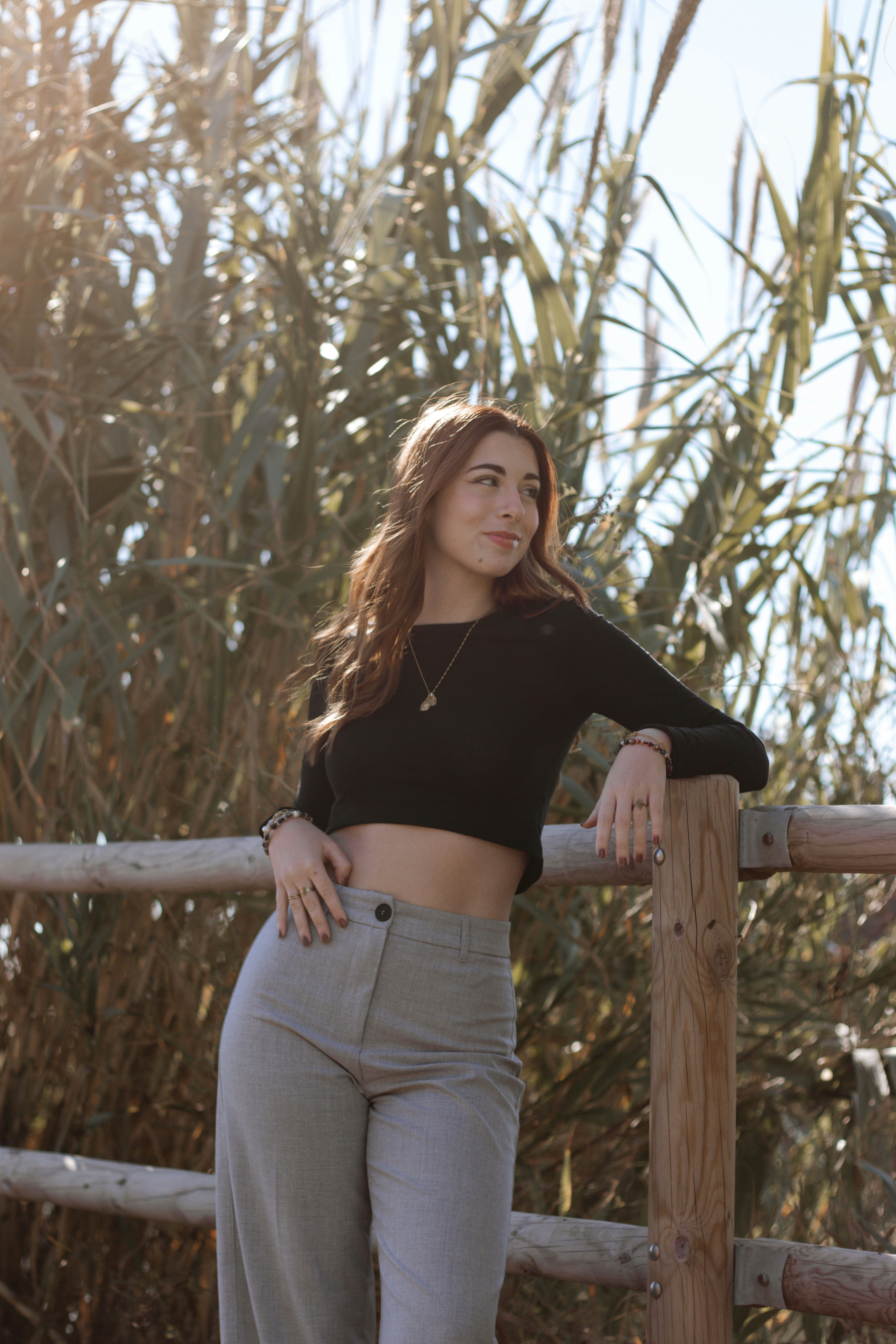 a woman leaning on a fence