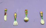 Brightly colored kitchen utensils arranged on a rustic wooden table.