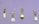 Four colorful utensils are arranged against a light purple background. Each utensil features a different floral pattern with vibrant yellows, greens, and reds. The utensils include a knife, a fork, a ladle, and a spoon.