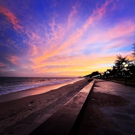 A vibrant photo of Regina filming a beach club event at sunset on the northern coast.
