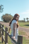 a woman leaning on a fence