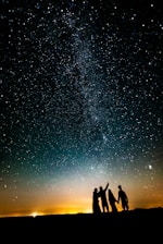 a group of people standing in front of a starry sky
