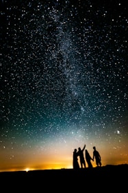 a group of people standing in front of a starry sky