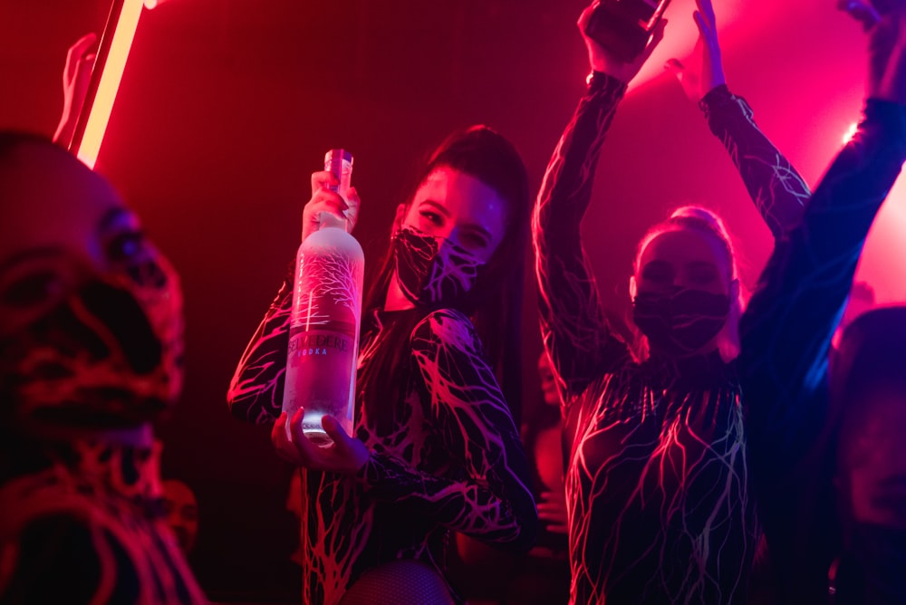 a group of people holding bottles