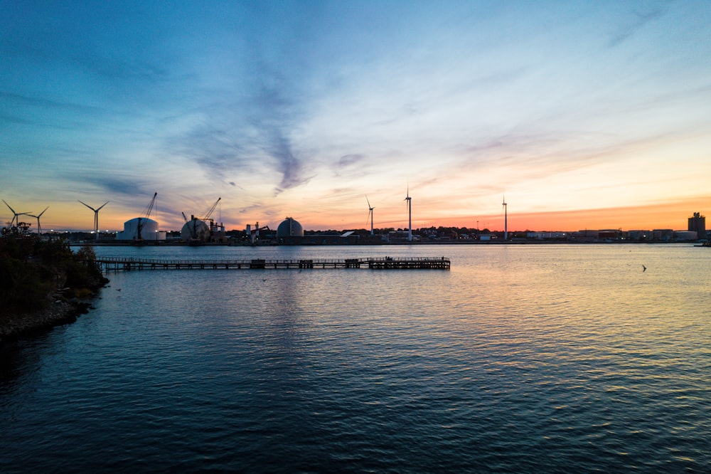 a body of water with a dock and buildings in the background