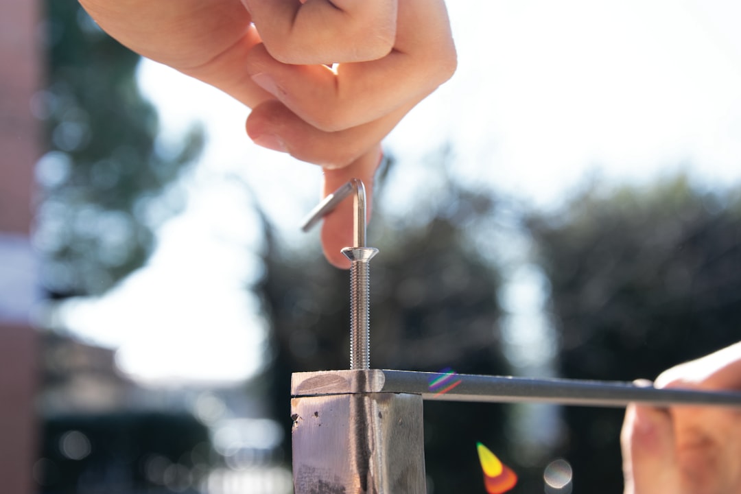 a hand holding a metal rod,