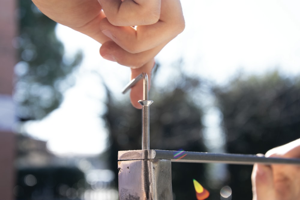 a hand holding a metal rod