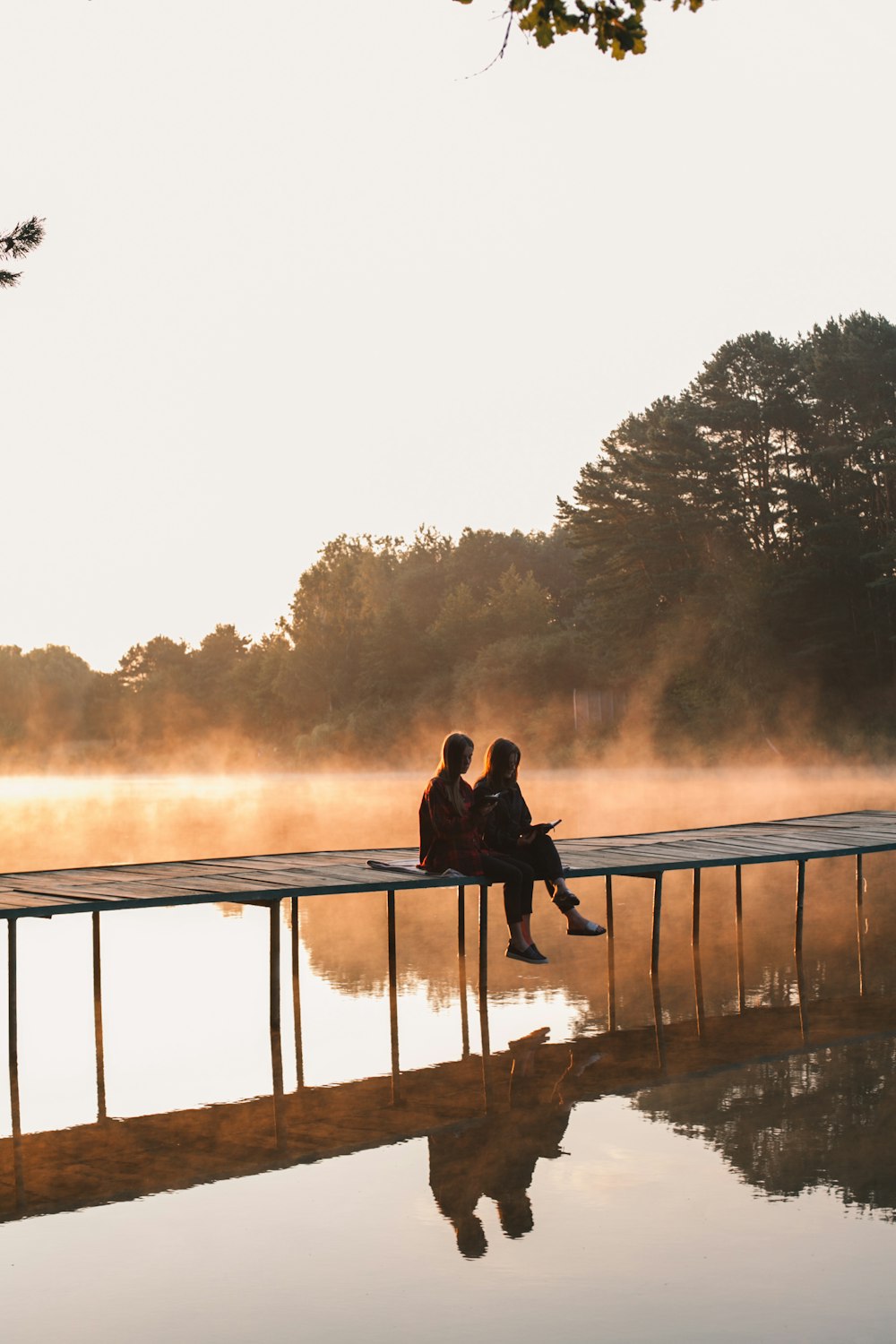 호숫가 부두에 앉아 있는 남자와 여자