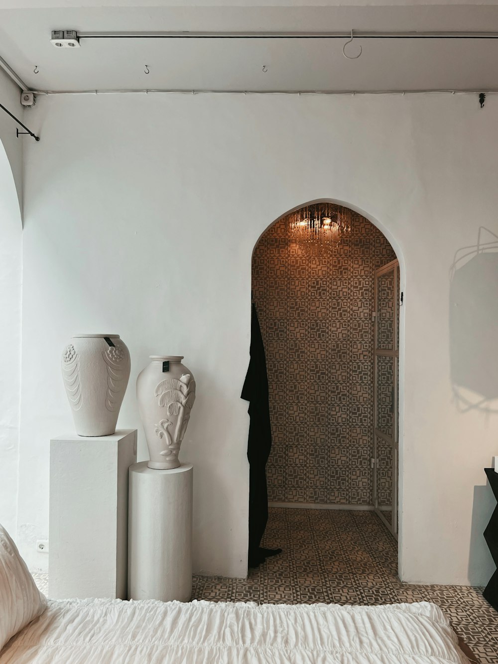 ein Raum mit einer großen Tür und einer Vase an der Seite