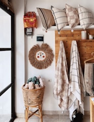 A cozy corner featuring woolen cushions and a crochet wall hanging.