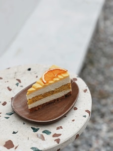 Slices of vibrant orange cake and classic lamingtons arranged on a white plate